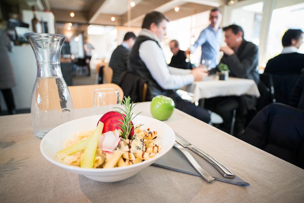 Une assiette dressée au premier plan, la salle en service derrière